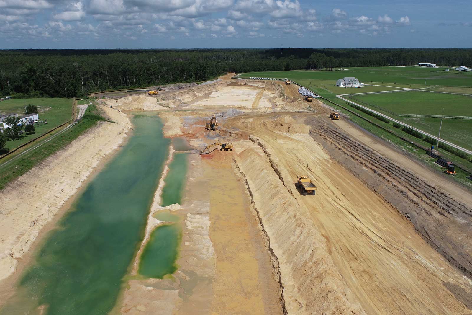 Excavation of a borrow pit off Sunset Drive, one of several required for the project. The contractor entered into an agreement with a private property owner to allow direct access, allowing the use of off-road equipment instead of over-the-road hauling.